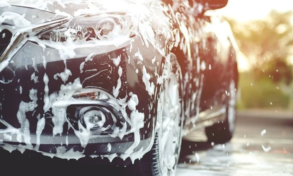 Car covered in soap during a detailing wash, highlighting the importance of regular car maintenance and preparation for ceramic coating.